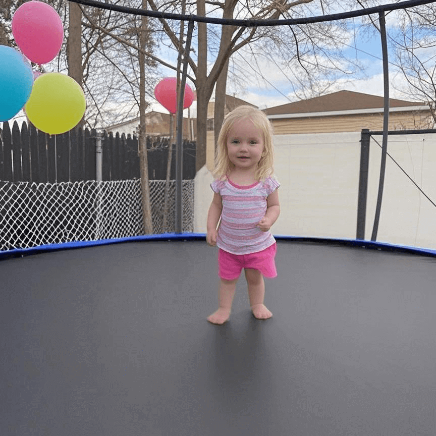 A little girl is standing on the MyFunGear trampoline